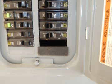 Breaker panel with an open slot in the cover